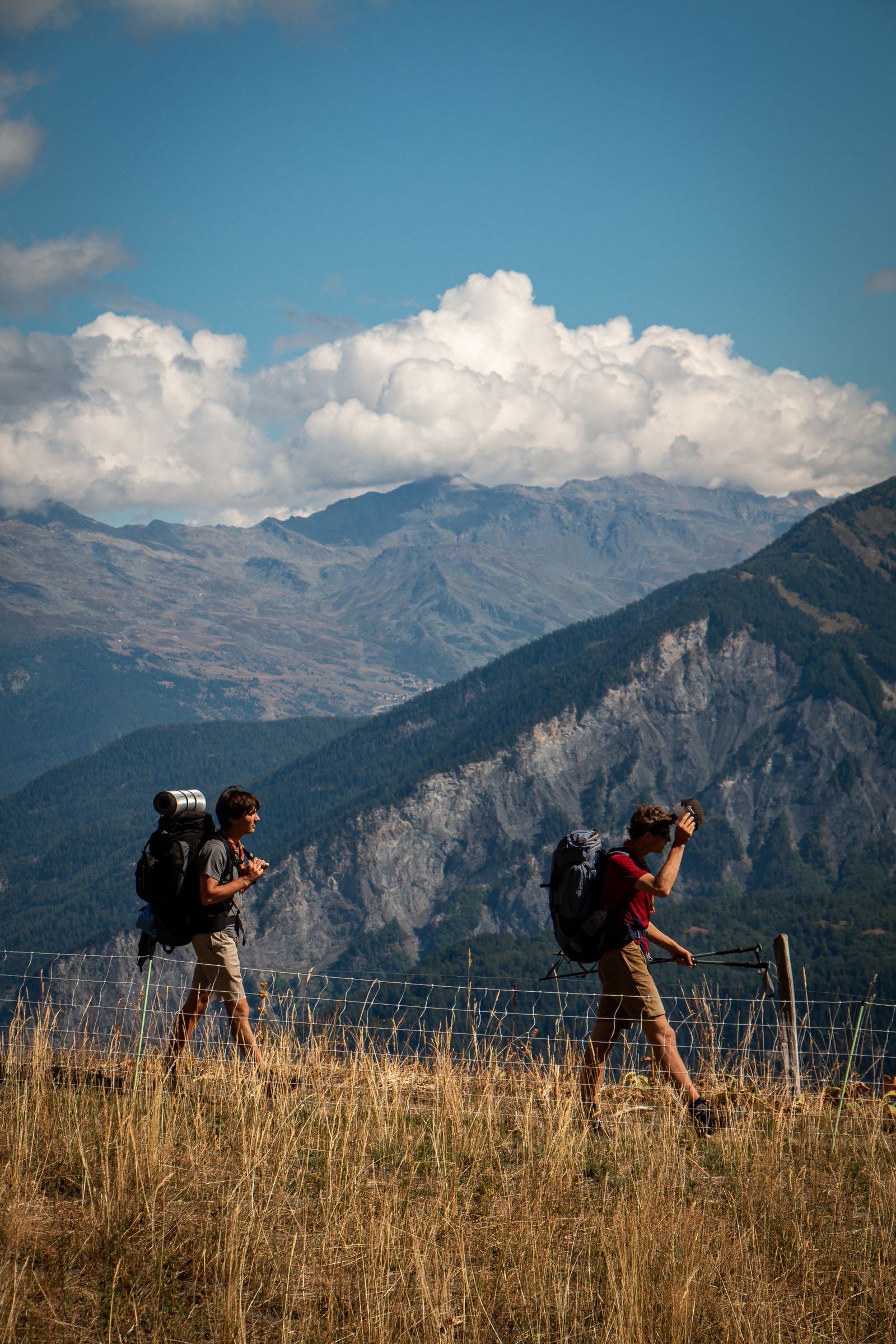 Two hikers walking through a mountain landscape