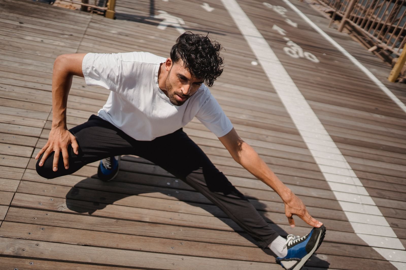 A man stretching on a wooden deck outdoors